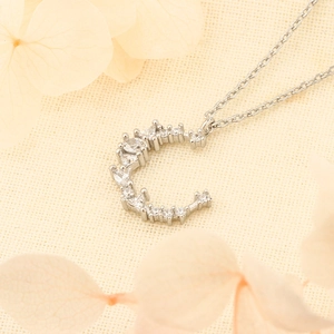 Élégant collier lune en argent avec cristaux scintillants sur fond en tissu texturé