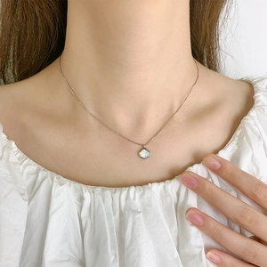 Elegant shell pendant necklace on model with shimmering white shell inlay in silver frame