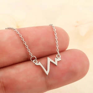 Minimalist heartbeat pendant necklace in silver metal finish with a sleek wave design
