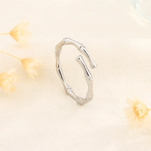 Bamboo-style S925 sterling silver open ring on textured fabric with floral accents