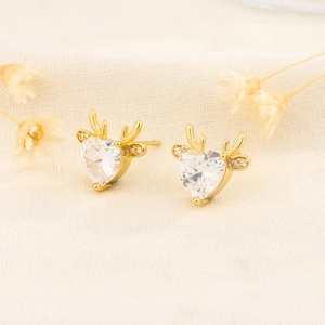 Exquisite golden heart-shaped reindeer antler earrings with white zircon on linen
