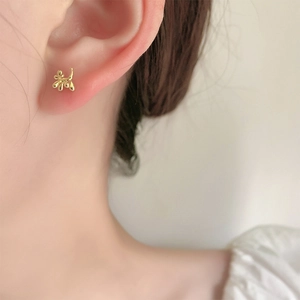 Puce d'oreille chien ballon doré portée par un mannequin pour un look quotidien chic