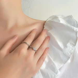 Anelli di coppia in argento 925 con trama intrecciata e zircone sulla mano della modella