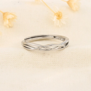 Anello aperto intrecciato in argento 925 con design regolabile su lino beige