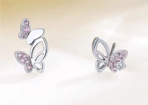Macro detail of asymmetric pink butterfly earrings with silver plating and zircon stones