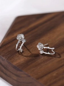 Detailed macro shot of silver rose stud earrings with sparkling centerpiece diamond