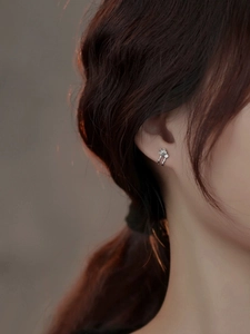 Close-up of 925 silver camellia earrings on model with elegant rose petal details