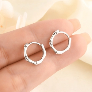 Macro shot of silver bamboo joint hoop earrings with inlaid sparkling zircons