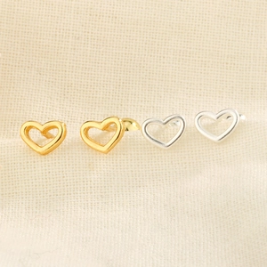Close-up of minimalist S925 silver hollow heart stud earrings in gold and silver colors