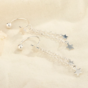 Macro detail of S925 silver star tassel ear cuffs with hanging chain star pendants