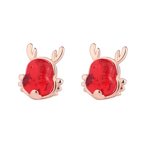 Macro detail of red reindeer stud earrings with rose gold horns for Christmas