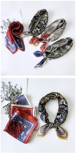 Détail du foulard en soie avec motifs paisley classiques et texture satinée élégante