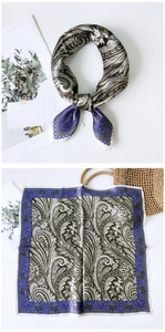 Détail macro du foulard en soie avec motifs paisley vert olive et bordure violette