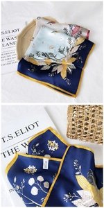 Detail of floral silk scarf featuring navy blue and gold patterns with 100% silk wash label