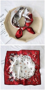 Detail of silk square scarf showing vintage burgundy floral patterns and smooth satin texture
