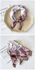 Detail of silk square scarf featuring pink floral and butterfly prints with brown edges