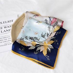 Elegant silk square scarf with botanical print and shell patterns on textured stone