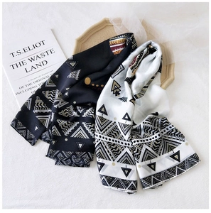 Dettaglio di un elegante foulard in seta con motivi geometrici etnici e tocchi dorati
