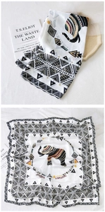 Dettaglio di un foulard di seta con stampa elefante e bordi geometrici su fondo bianco