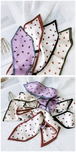 Détail de foulards étroits en soie à motifs de cœurs pour femmes comme rubans décoratifs