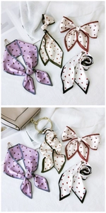 Détail de foulards en soie à motifs de cœurs noués en nœuds aux couleurs élégantes