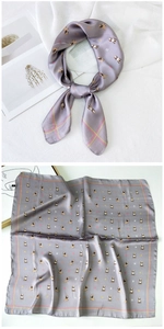 Detail of silk square scarf featuring puppy pattern and elegant lavender checkered borders