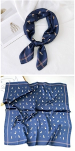 Detail view of navy blue silk scarf with dog prints and colorful decorative borders