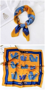 Detail of yellow silk scarf featuring vintage belt print and navy blue striped patterns