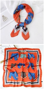 Detailed view of an orange silk-texture square scarf with retro belt and chain patterns
