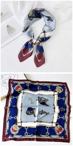 Close-up of a square silk scarf featuring equestrian motifs like buckles and chains
