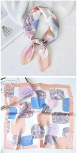 Detail of pink and blue paisley silk scarf with elegant floral patterns on satin fabric