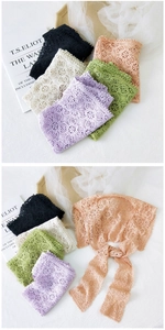 Close-up of floral lace crochet scarves in multiple colors with delicate tassel ties