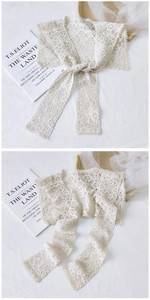Detail of floral lace hollow shawl in beige with elegant crochet patterns and ribbon tie