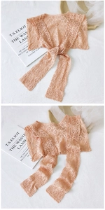 Detail of apricot floral lace shawl showing intricate crochet patterns and ribbon tie