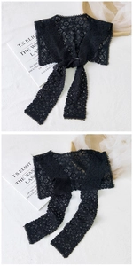 Close-up of black floral lace shawl with hollow-out texture and soft ribbon ties
