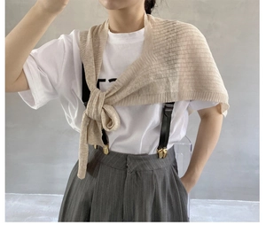 Detail eines beigen Strickschals, gestylt über einem weißen T-Shirt für den Sommer-Lagenlook
