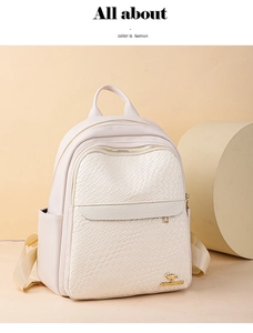 Detail view of cream leather backpack featuring crocodile texture and gold kangaroo logo