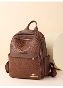 Detailed view of dark brown textured leather backpack with woven pattern and gold logo