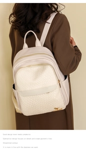 Detail of beige faux leather backpack with woven texture panel and gold metal logo