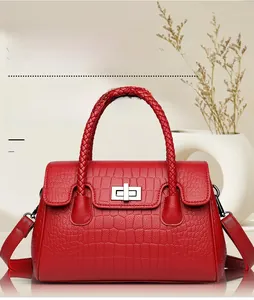 Detail of red crocodile embossed leather texture and silver twist lock on stylish handbag