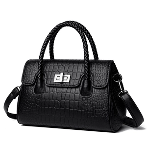 Black crocodile pattern handbag with woven handle and silver twist lock on white background