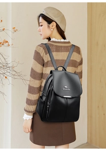 Detail of black textured leather backpack with metal kangaroo logo and side pocket