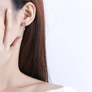 Close-up of elegant silver drop earrings with water drop zircon worn by a model