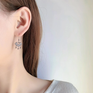 Dettaglio degli orecchini a lucchetto Ruyi in argento con micro-intarsi indossati da modella
