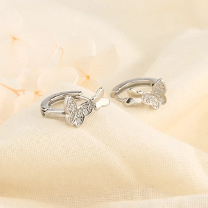 Silver double butterfly huggie earrings with shimmering crystals on minimalist hoops