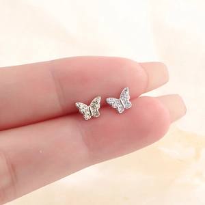 Détail macro de boucles d'oreilles papillon en argent avec pavé de zircons brillants