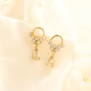 Elegant gold drop earrings with water droplet zircon crystal on white textured fabric