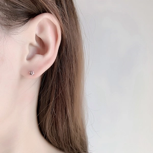 Close-up of a minimalist silver star geometric stud earring worn on the earlobe
