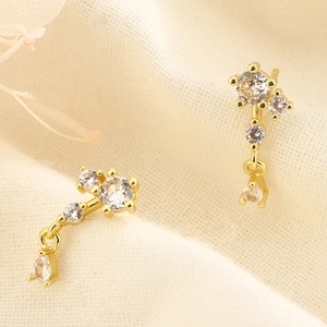 Vue détaillée de boucles d'oreilles dorées en forme de note avec zircons clairs