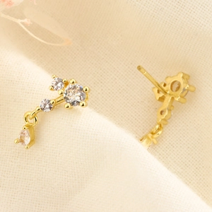Boucles d'oreilles note de musique dorées avec zircons sur tissu en lin beige